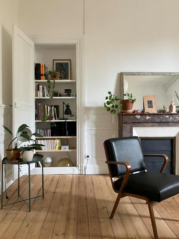 - un salon avec une chaise et une cheminée dans l'établissement Appartement d'architecte, à Saint-Brieuc