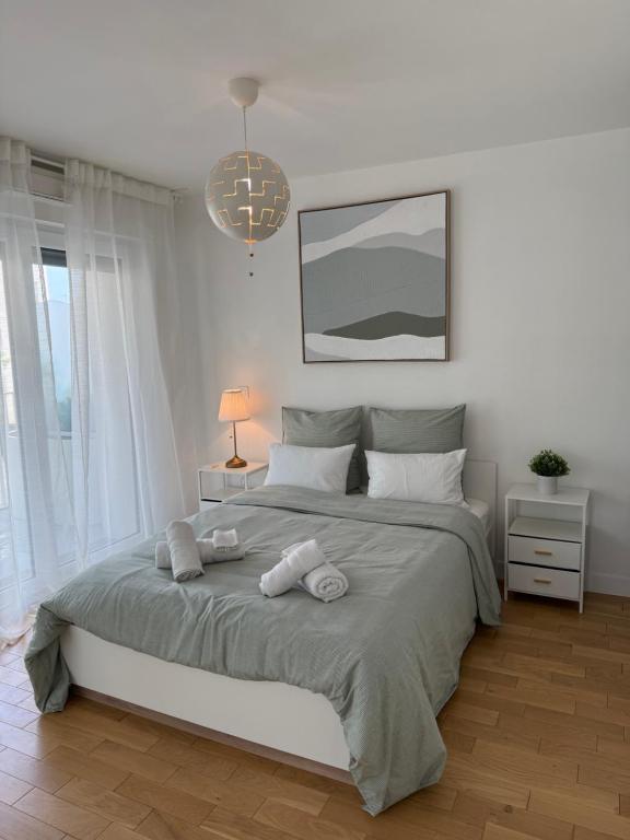 une chambre avec un grand lit avec deux serviettes dessus dans l'établissement Luxury and Cozy Apartement In la Defense-Paris, à Courbevoie