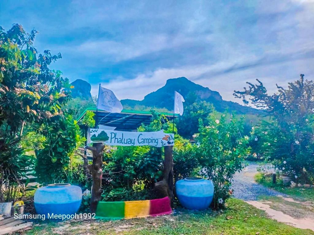 ein Schild für einen tropischen Lebensmittelladen mit einem Regenbogen in der Unterkunft PhaluayCamping in Koh Phaluai