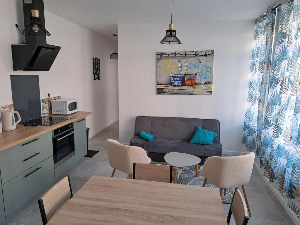 une cuisine et un salon avec un canapé et une table dans l'établissement La baraque bleriot beach, à Sangatte