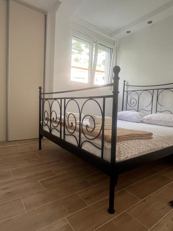 Cama negra en habitación con ventana en Apartman Pablo, en Kotor