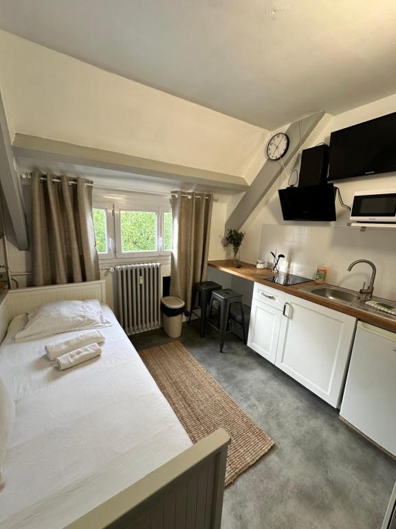 une chambre avec un grand lit et une cuisine dans l'établissement STUDIO proche commodité et gare . Centre ville, à Caen