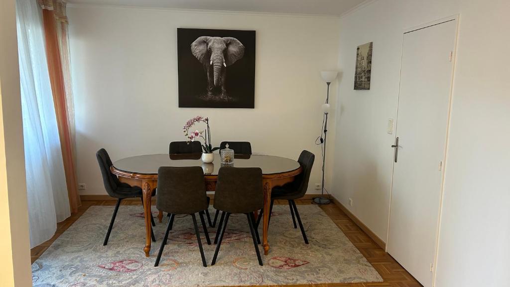 une table à manger avec des chaises et un éléphant sur le mur dans l'établissement Appartement près de Paris et Disneyland, à Boissy-Saint-Léger