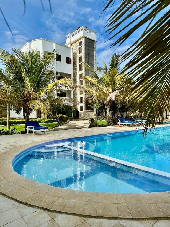 a large swimming pool in front of a building at Azar Stays Diani in Diani Beach