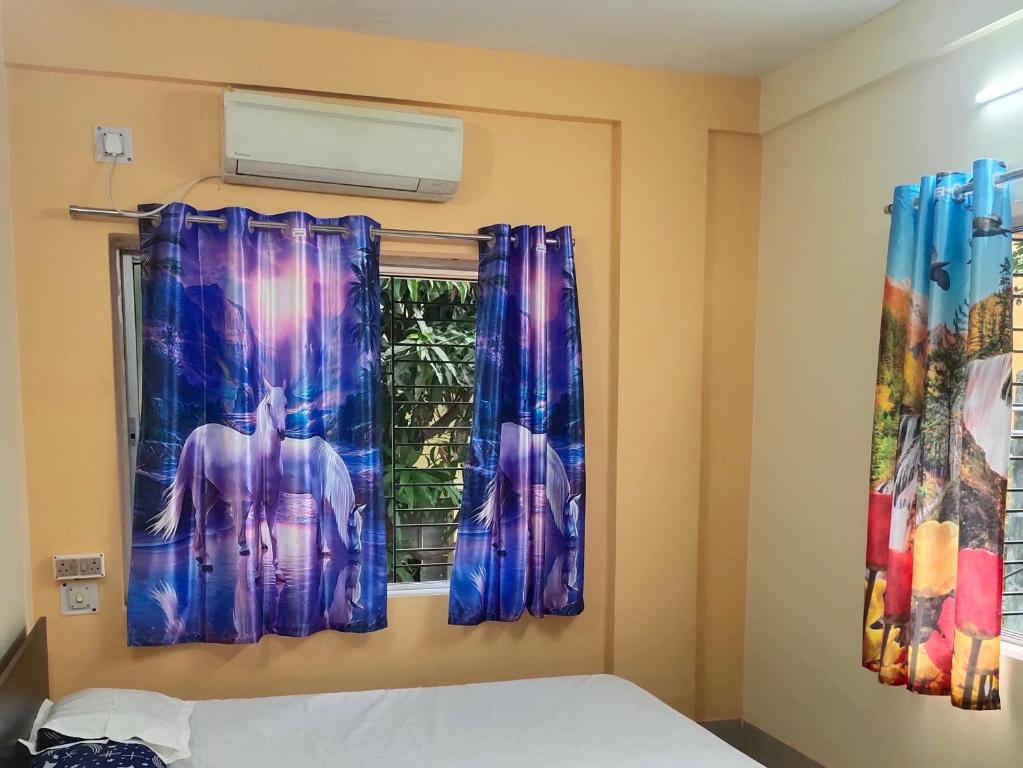 une chambre avec une fenêtre avec des rideaux bleus dans l'établissement DeeP HERITAGE 2, à Kolkata