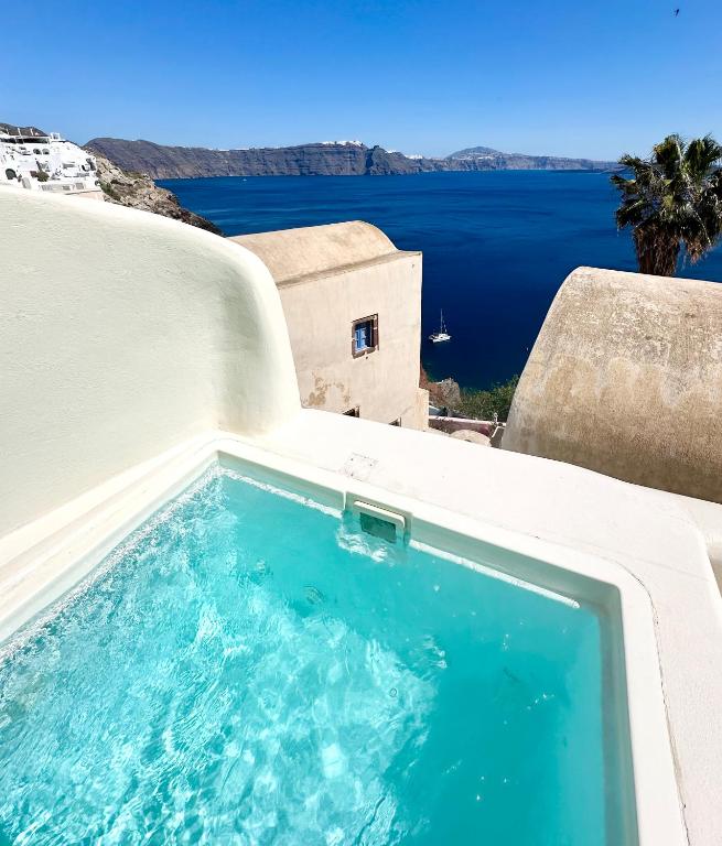 a swimming pool with a view of the water at Ilia Oia in Oia