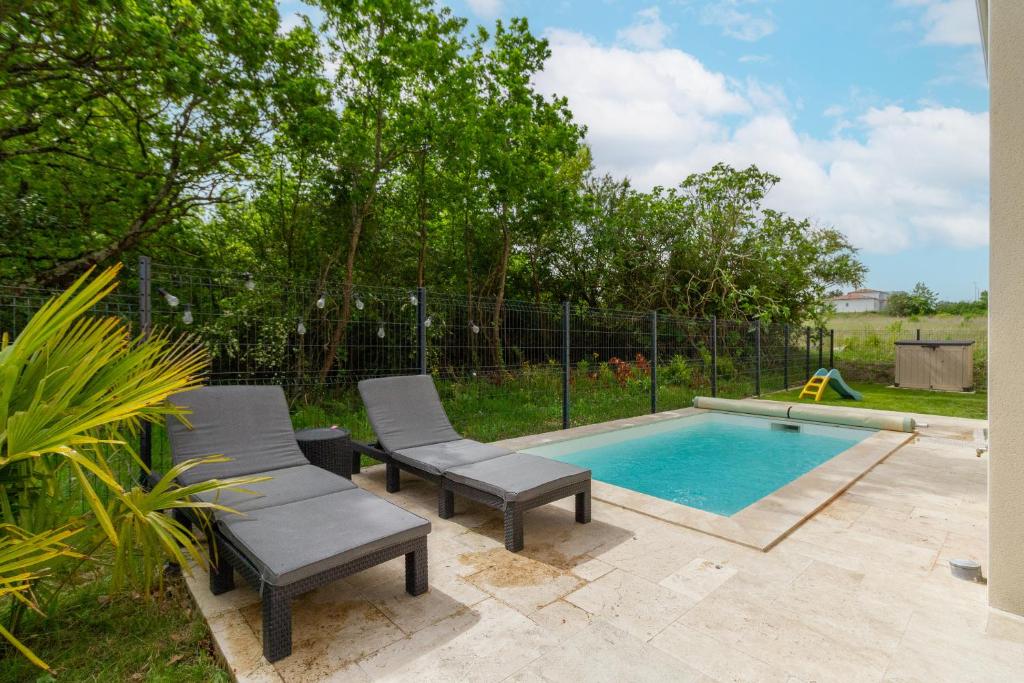 オーズヴィル・トロザーヌにあるMaison avec piscine, au calme près de Toulouseのパティオ(椅子2脚付)、スイミングプールが備わります。