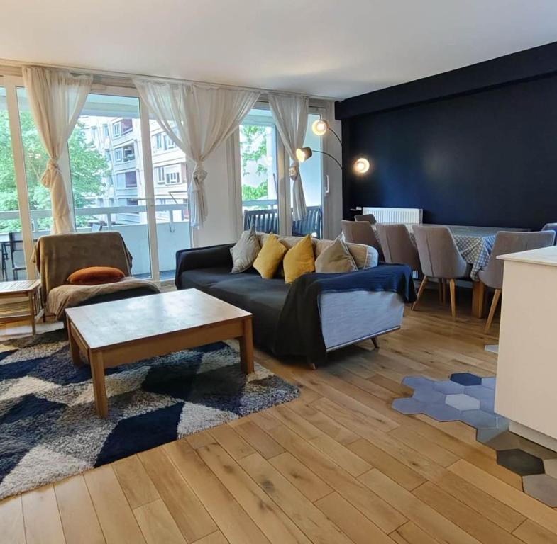 un salon avec un canapé bleu et une table dans l'établissement Cozy 3 bedrooms, 5 mn 450m walk Metro La Defense, à Courbevoie