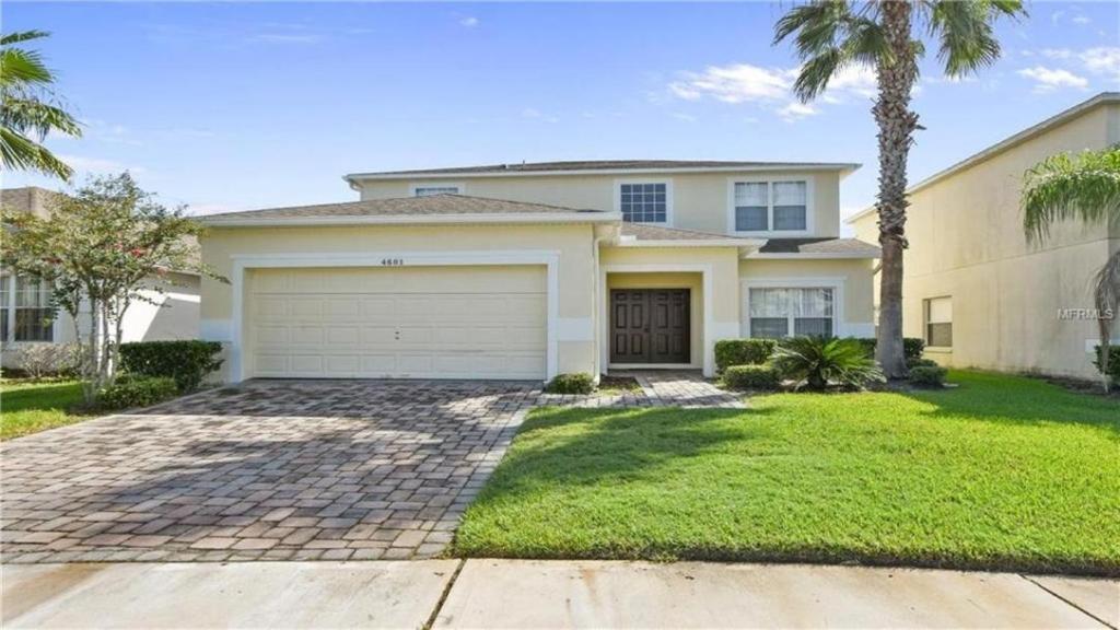 a large house with a garage and palm trees at Kissimmee in Kissimmee
