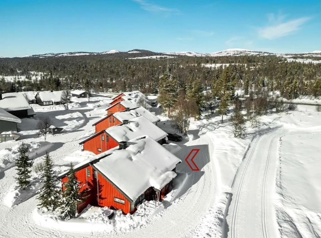 an orange barn covered in snow with trees in the background at Modern cabin in amazing hiking area! in Gol