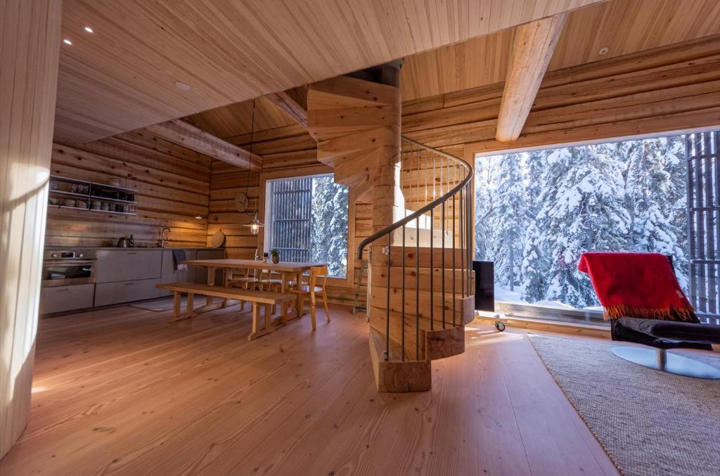 un soggiorno con scala in una casa di legno di Handcrafted Log Chalet Villa Aarreaitta a Pudasjärvi