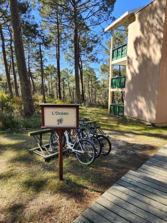 - un groupe de vélos garés à côté d'un panneau dans l'établissement Résidence les Grands Pins, à Carcans