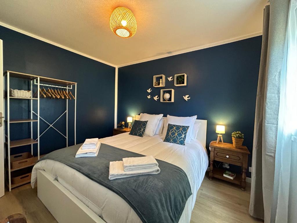 une chambre avec un grand lit aux murs bleus dans l'établissement 4 couchages, proche plage et port, au Cap d'Agde
