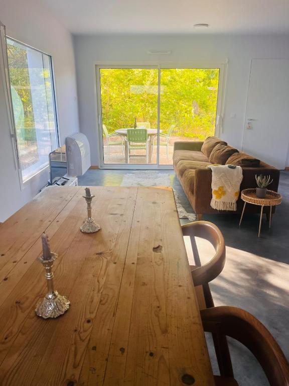 un salon avec une table en bois et un canapé dans l'établissement modern appartement with private garden & shared pool, à Seignosse