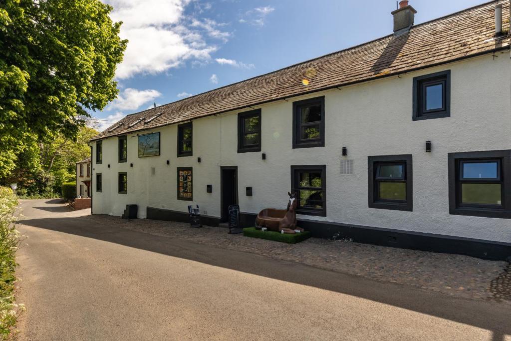 a white building with black windows on a street at The Kellbank in Gosforth