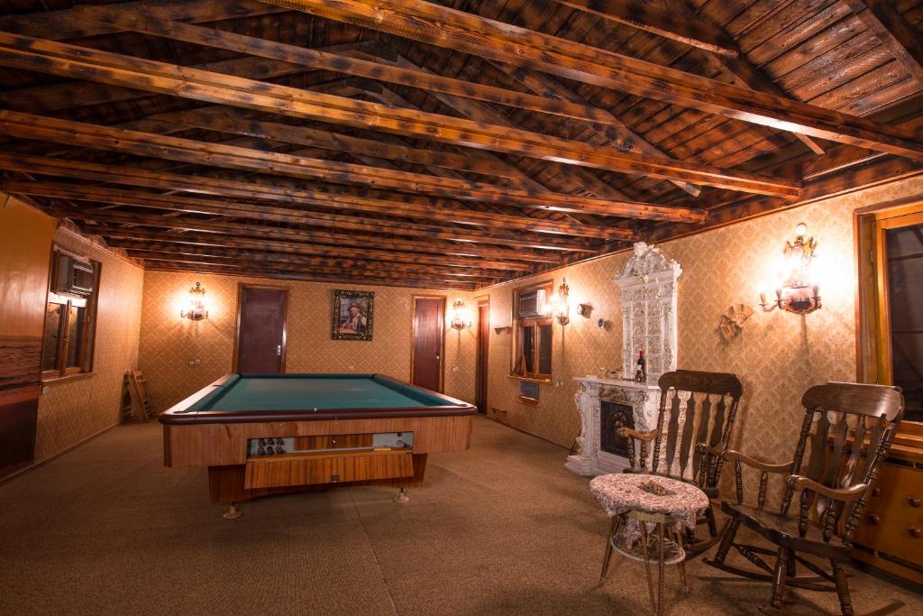 a room with a pool table and two chairs at Guest House Top Floor in Telavi
