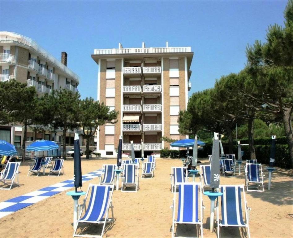 un gruppo di sedie e ombrelloni su una spiaggia di Fronte Mare Apartment Private Beach & Free Park a Lido di Jesolo
