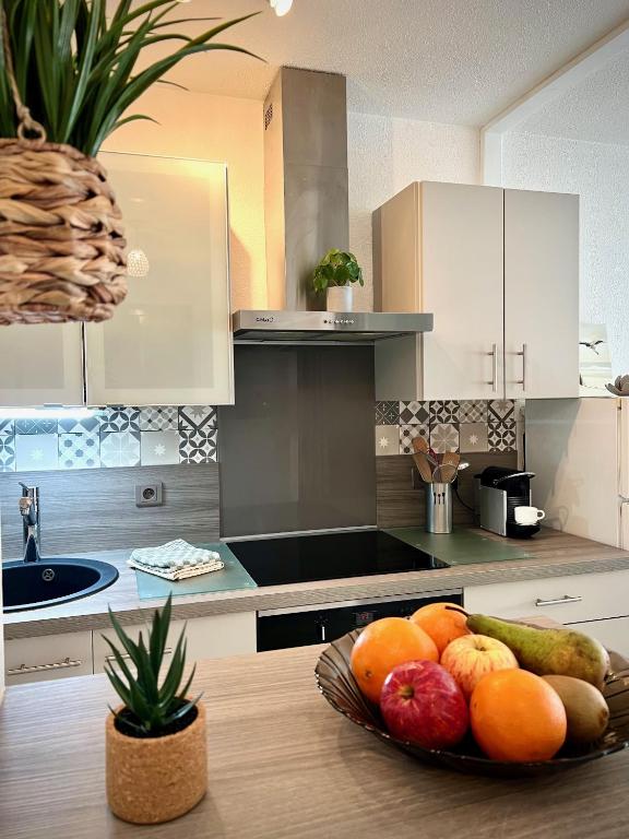 une cuisine avec une assiette de fruits sur une table dans l'établissement Les Océanes, à Les Sables-dʼOlonne