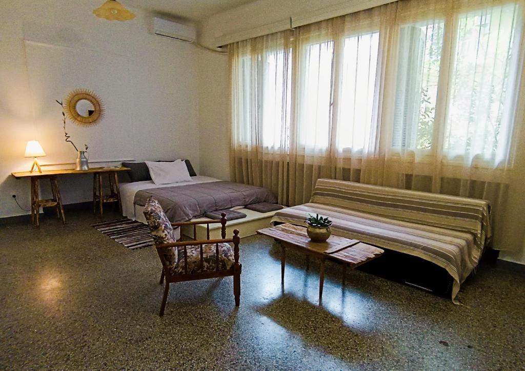 een slaapkamer met twee bedden, een tafel en een raam bij The SPiTi Project 13 in Kavala