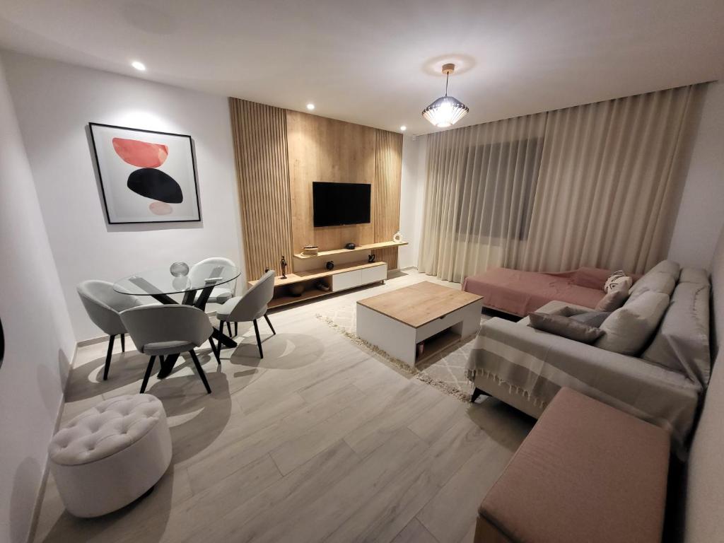 una sala de estar con un sofá y una mesa en Le luxe appartement, en El Haouach