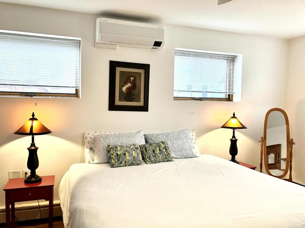 1 dormitorio con 1 cama con 2 lámparas y 2 ventanas en Luxury, Convenience and Comfort Near Acadia!, en Ellsworth