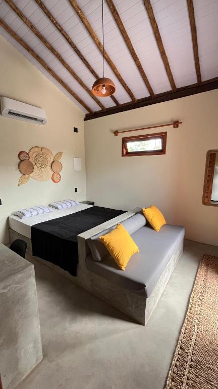 a bedroom with a large bed with yellow pillows at Vila São Jorge in Barra Grande