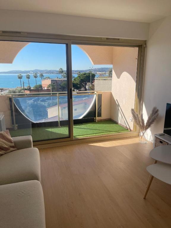 - un salon doté d'une grande fenêtre offrant une vue sur la piscine dans l'établissement Sea View Apartment 50 m to Beach FREE Parking, à Cagnes-sur-Mer