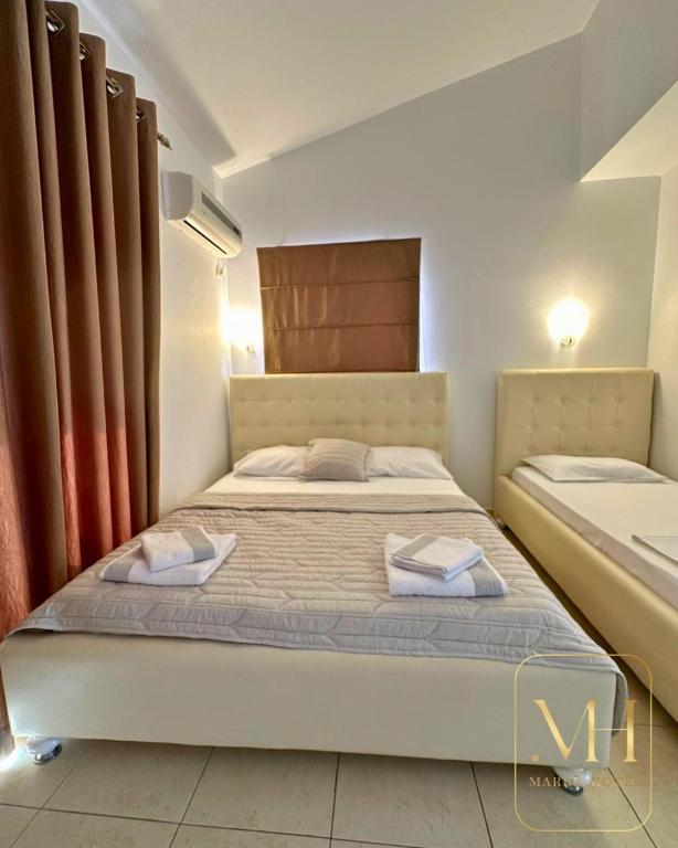 a bedroom with a bed with two towels on it at Hotel Marku in Ksamil