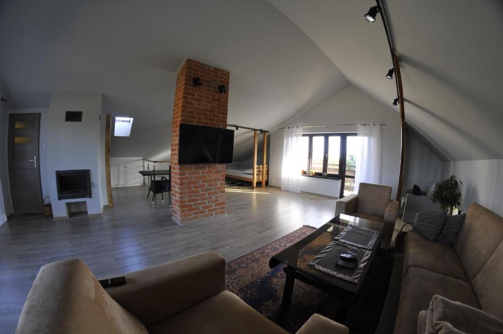 Una sala de estar con un sofá y una chimenea. en Świerkowe Zacisze Nałęczów, en Nałęczów