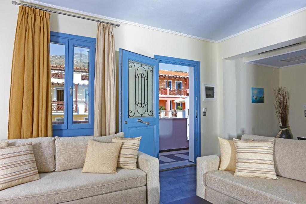 a living room with a couch and a blue door at Sirena Residence & Spa in Marathokampos