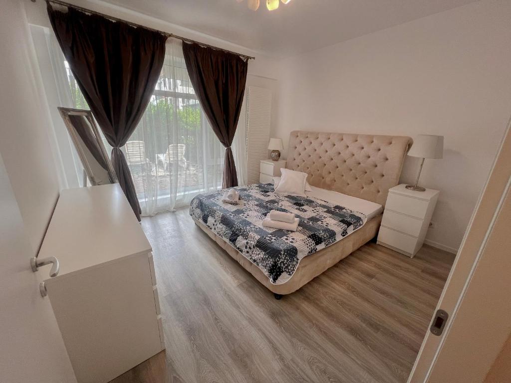 a bedroom with a bed and a large window at Golden Lake Escape in Bucharest