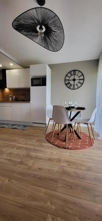- un salon avec une table à manger et un ventilateur de plafond dans l'établissement Appartement les hauts de balaruc L' escapade T2 rénové parking climatisation et piscine, à Balaruc-les-Bains