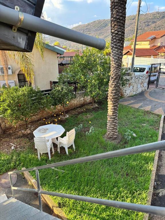 a table and two chairs and a palm tree at מול ההר in Shelomi