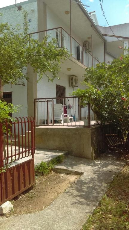 a house with a fence and a chair on the porch at Peaceful House in Tribunj in Tribunj