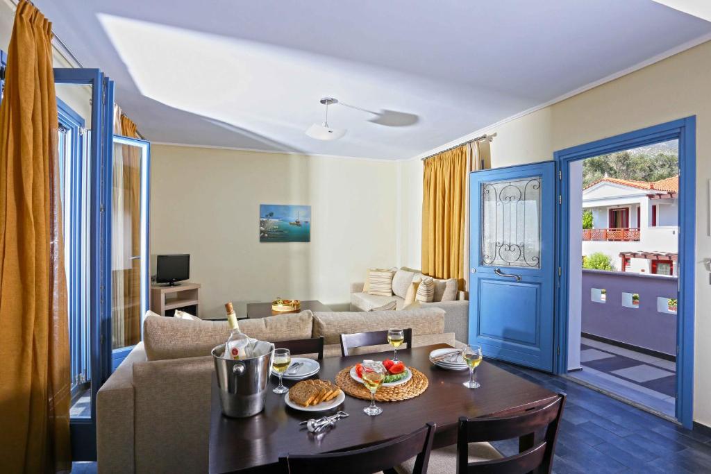 a living room with a table and a couch at Sirena Residence & Spa in Marathokampos