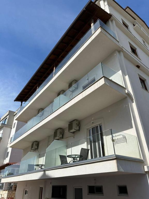 a white building with a balcony with chairs on it at Hotel Marku in Ksamil