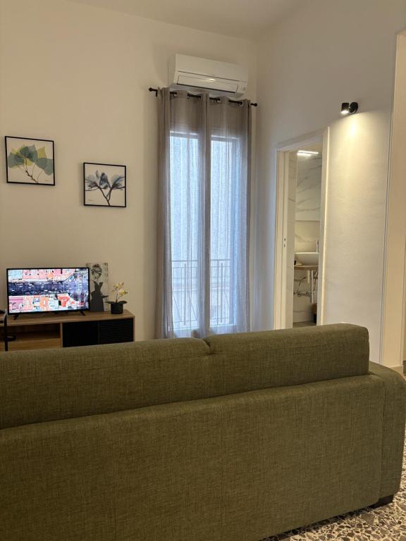 a living room with a green couch and a television at La Casa verde in Galatone