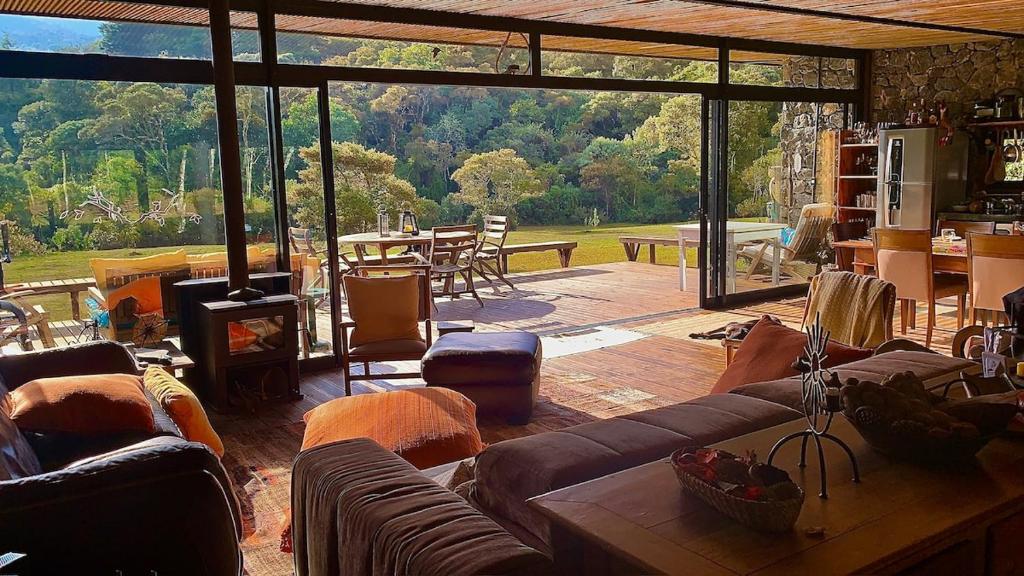 ein Wohnzimmer mit Sofas und einem großen Glasfenster in der Unterkunft Fazenda Caminho do Ouro in São José do Barreiro