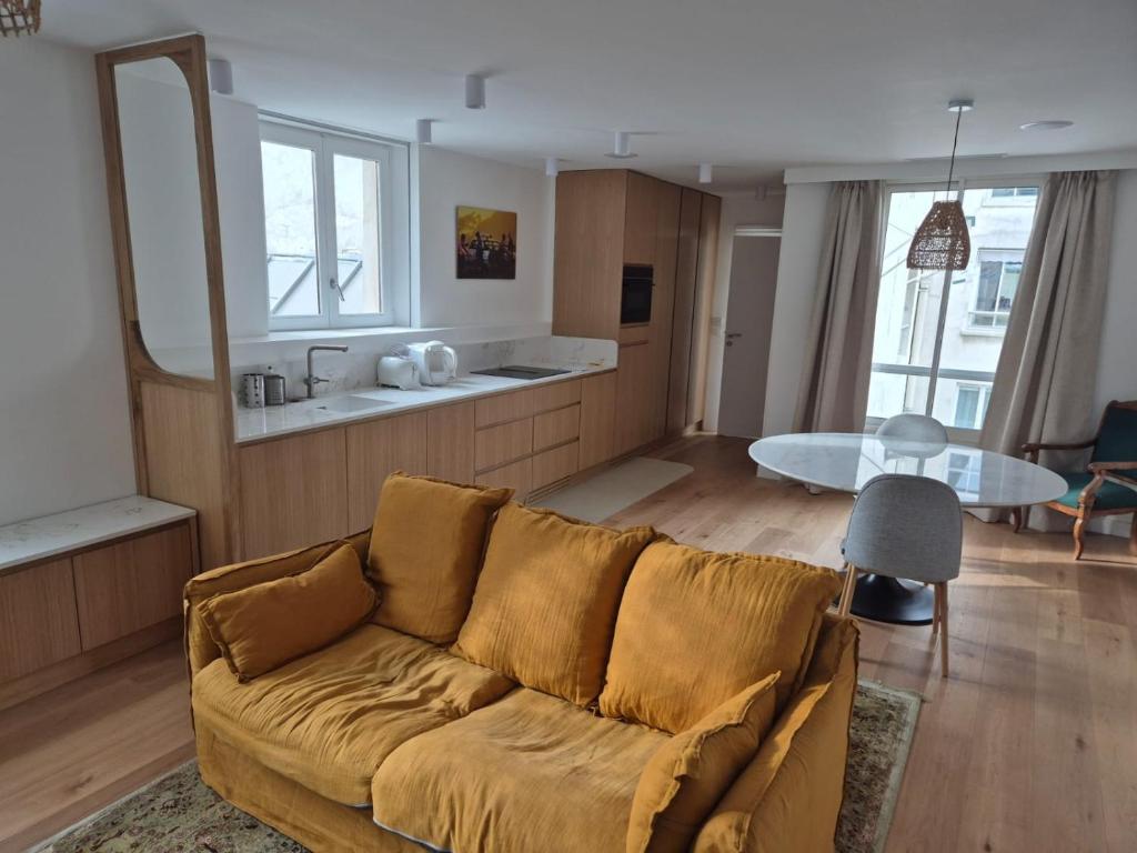 ein Wohnzimmer mit Sofa und Tisch in der Unterkunft Cozy apt Paris centre, 5 mins Louvre in Paris