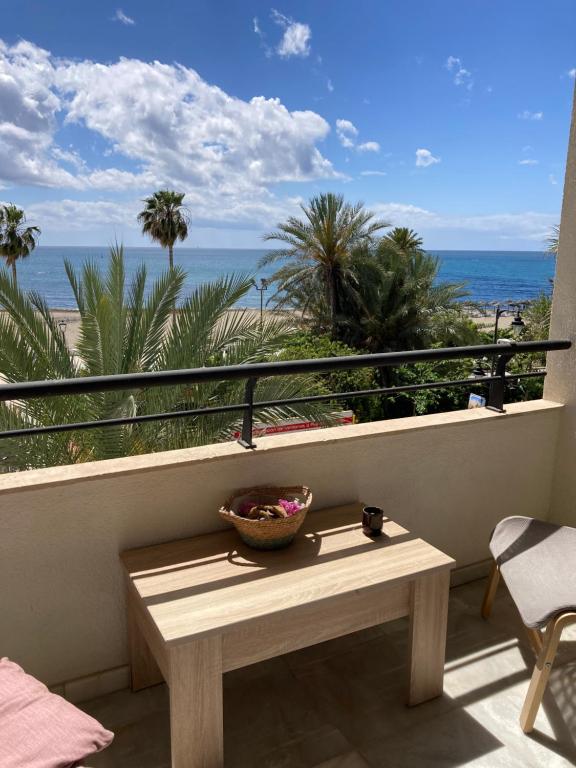 a table on a balcony with a view of the beach at Holidays beach Estepona in Estepona
