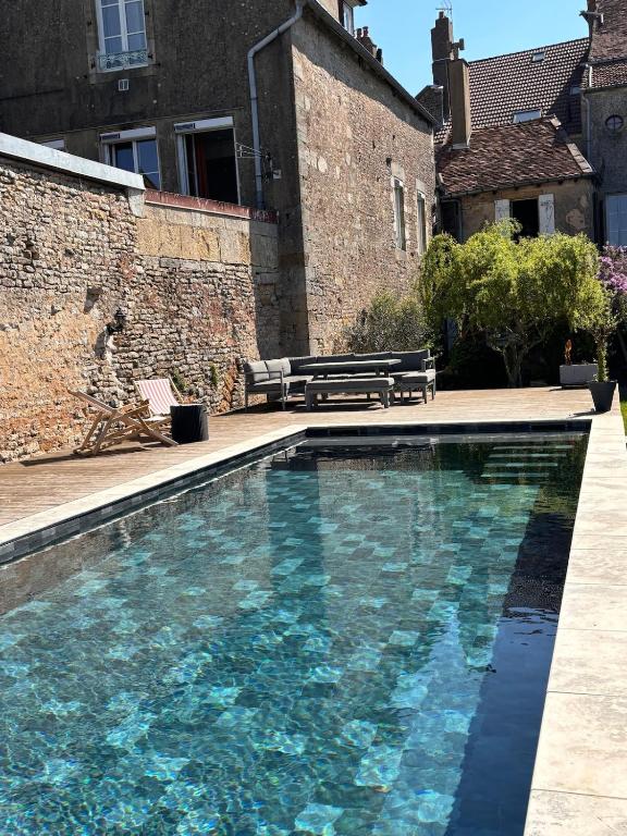une piscine devant un bâtiment en briques dans l'établissement Maison intra muros, à Langres