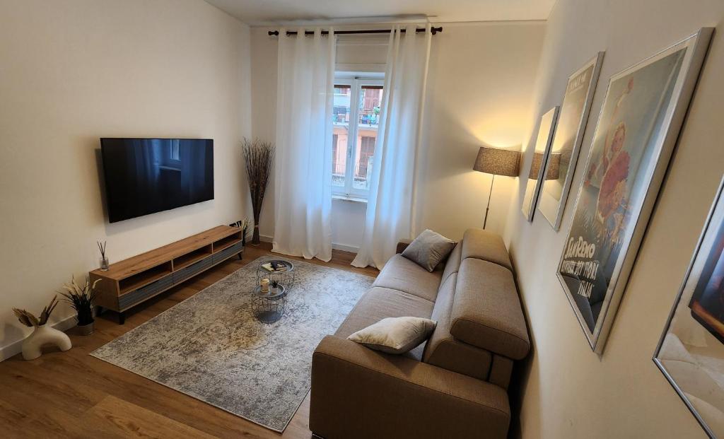 a living room with a couch and a flat screen tv at CLASSY HOMES - A due passi dal mare in Sanremo