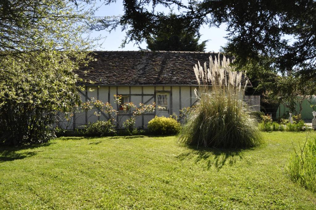 a house in a yard with a grass field at Les rouches in Cormeray