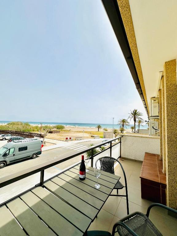 a bottle of wine sitting on a table on a balcony at Apartamento en primera línea de mar in Hospitalet de l'Infant
