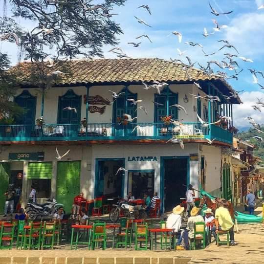a group of people sitting outside of a building at El Balcón de Emma in Jardin