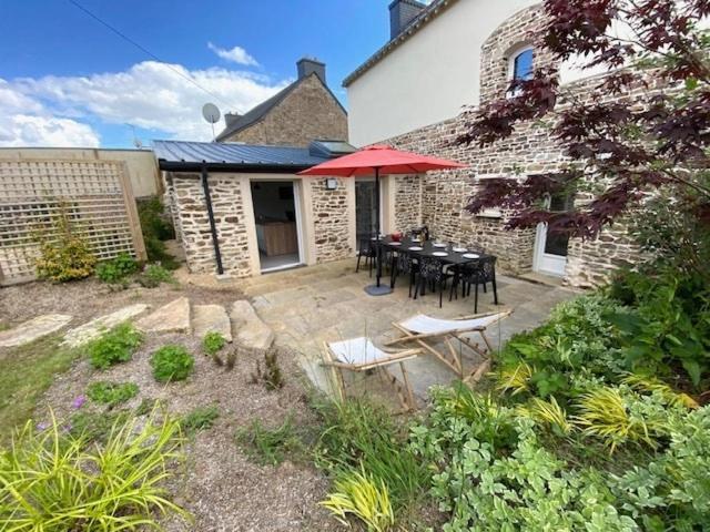 eine Terrasse mit Tisch und Stühlen vor einem Gebäude in der Unterkunft Villa La Glycine in Saint-Avé