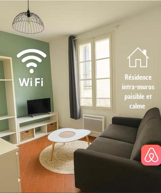 un salon avec un canapé et un panneau wifi sur le mur dans l'établissement L'harmonie de Saint Lazare 2, à Avignon