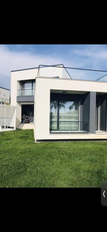 ein großes weißes Haus mit einem Rasen davor in der Unterkunft Cheerful 3 bedroom villa with free parking seeview in Hamallë