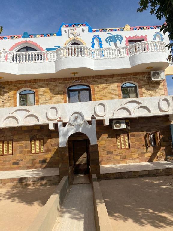 a brick building with a balcony on top of it at Maleka nubian guest house in Aswan