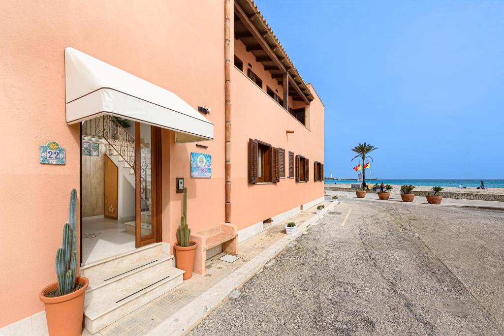 un edificio sulla spiaggia con un cactus all'esterno di Beach View Apartment a San Vito lo Capo